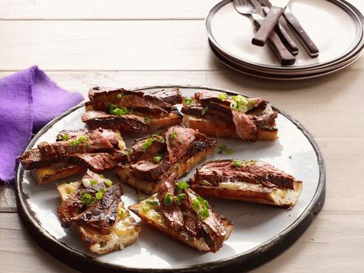 Foto de carne até churrasco com molho balsâmico e torradas de queijo