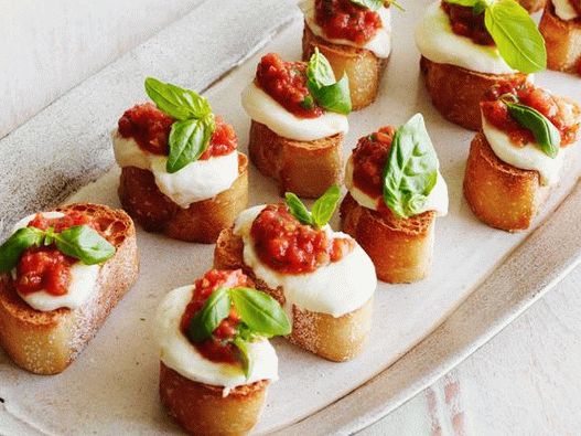Foto de Bruschett com tomate, mussarela e manjericão