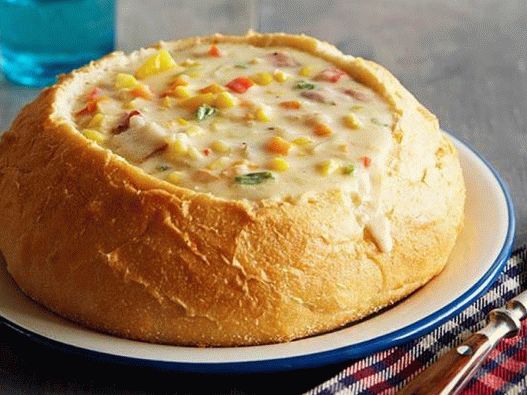 Foto de uma sopa com milho e queijo em tigelas de pão