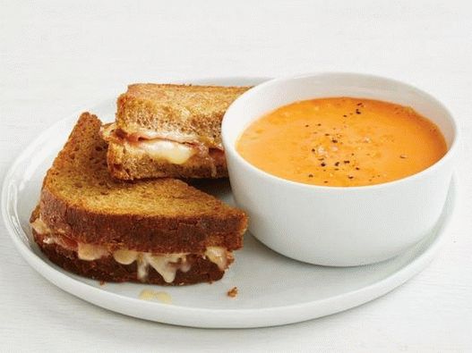 Foto sanduíches quentes com queijo e presunto espanhol com gaspacho