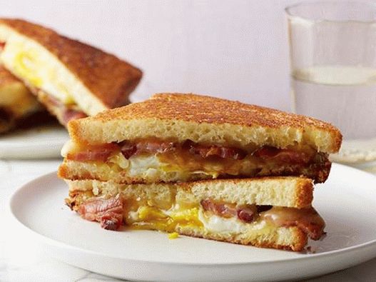 Foto sanduíche quente com queijo, bacon, ovo e xarope de bordo