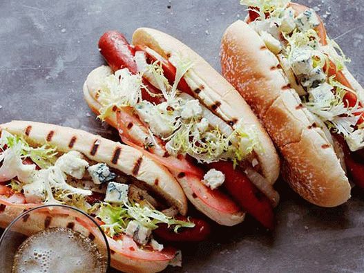 Foto Cachorro-quente com salsichas, queijo gorgonzola, tomate, cebola e salada de frise