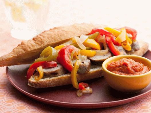 Foto Cachorro-quente com salsichas grelhadas, pimentão, cebola e molho de caril