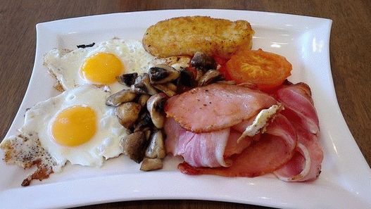 Foto café da manhã irlandês com ovos fritos, batatas fritas e tomates assados