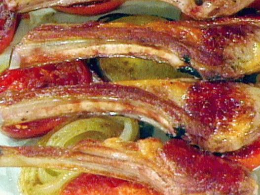 Foto de uma costela de carneiro em um travesseiro de tomate picante e cebola