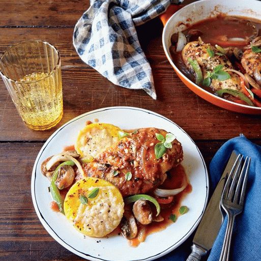 Foto Frango estufado em molho de tomate com cogumelos de caça (Frango Cacciatore) com polenta