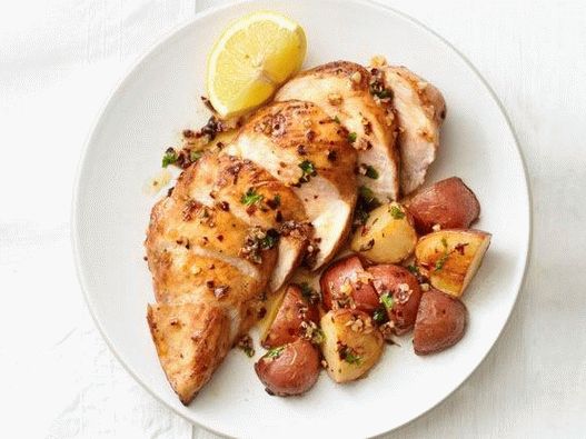 Foto de peitos de frango assados ​​com batatas e alho caramelizado