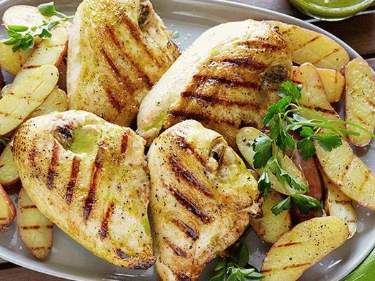Foto de peitos de frango e batatas jovens grelhadas com molho vinagrete com alho assado e orégano