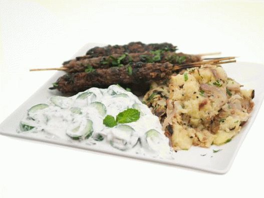 Foto de Kufta de cordeiro no espeto com cobertura de romã, batatas com especiarias de Bengala e molho raita