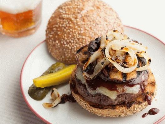 Hambúrgueres com costeletas em uma placa de grelha de cedro