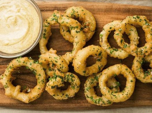 Foto anéis de cebola em massa de cerveja com molho de mostarda