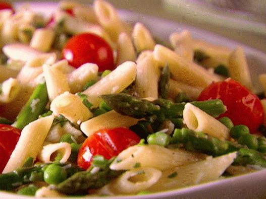 Foto de macarrão com aspargos, ervilhas jovens e tomate cereja