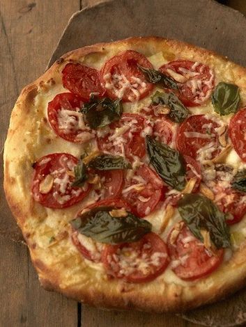 Foto pizza com tomate e manjericão