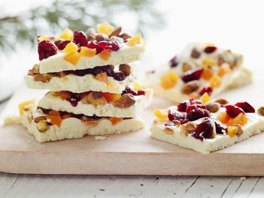 Foto Uma barra de chocolate branco com pistache inteiro, cranberries secas e damascos secos