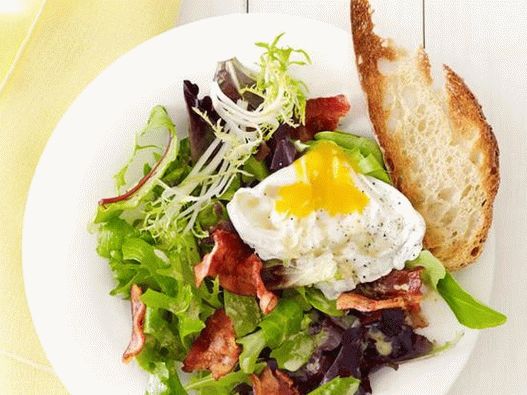Salada com ovo escalfado e bacon em um café