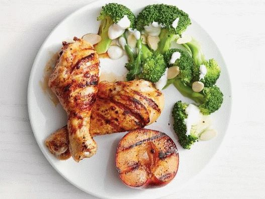 Foto frango picante com ameixas grelhadas e brócolis cozido em um prato