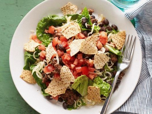 Salada de feijão com carne moída, molho de tomate e batatas fritas