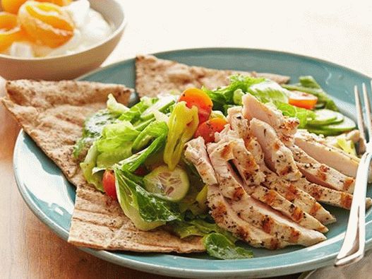 Salada com frango grelhado e damascos secos em um bolo grego