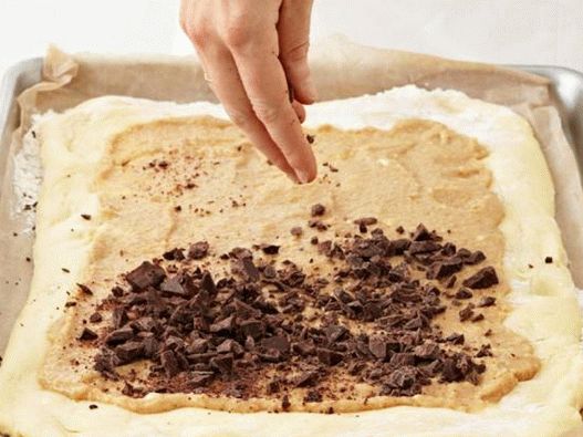 Espalhe a massa com recheio de amêndoa e polvilhe com chocolate