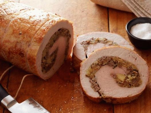 Foto rolo de carne de porco com recheio de maçã e carne picada