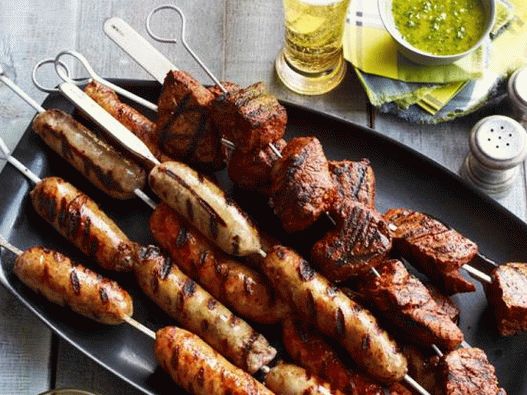 Foto espetos de bife e linguiça com dois molhos latino-americanos