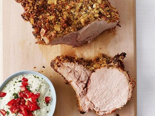 Foto Lombo de porco com osso com crosta de batata e pesto