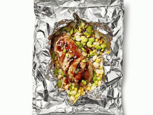 Foto Costeletas de porco com salada de sukkotash em pacotes de folhas grelhadas