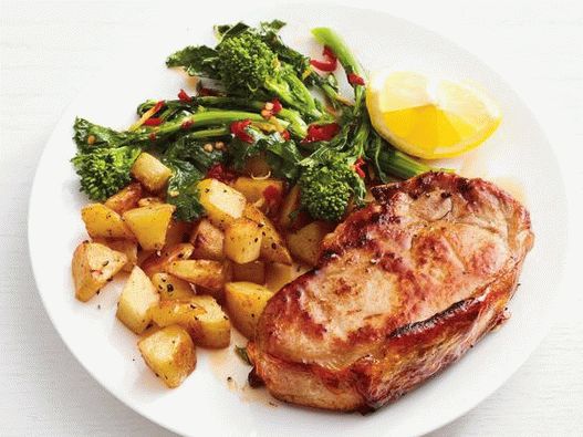 Foto Costeletas de porco com batatas e brócolis rapini