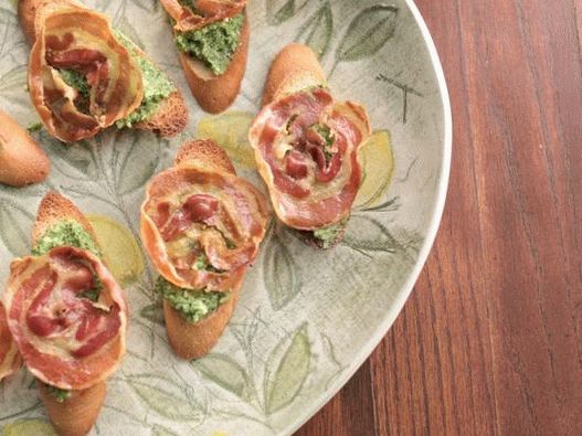 Crostini com pancetta crocante e pesto de rúcula