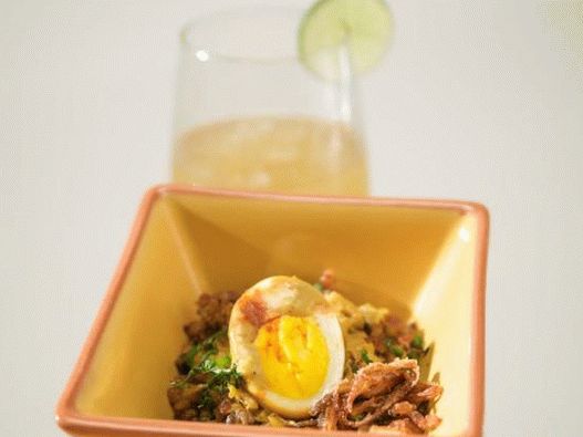Foto de ovos em molho de curry com guarnição de arroz e anéis de cebola